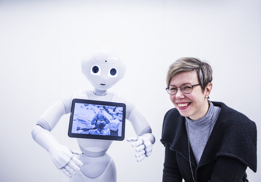 VTT:n tutkija Hanna Lammi ollut seisoo Pepper-robotin vieressä.